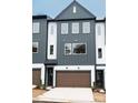 Beautiful exterior elevation of a modern townhome featuring a two-car garage and stylish gray and white siding at 7940 Cedarsmith Ct, Charlotte, NC 28217