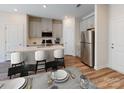 Modern eat-in kitchen with stainless steel appliances, gray cabinets, and a breakfast bar at 1602 Village Grove Ln, Monroe, NC 28110
