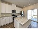 Modern kitchen with white cabinets, granite countertops, a mosaic backsplash, and stainless steel appliances at 849 Blue Canyon Dr, York, SC 29745