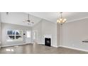 Open-concept living room with a cozy fireplace, ceiling fan, and a door to the outside at 8505 Loxton Cir, Charlotte, NC 28214