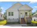 Charming new construction home with white siding, brick stairs, and a welcoming covered front porch at 1105 Kenly St, Salisbury, NC 28144