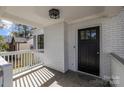 Inviting front porch with white railings and a black front door at 1320 Brook Rd, Charlotte, NC 28205