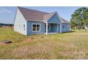View of the back of the light blue home, with ample green lawn at 220 W Lawyers Rd, Monroe, NC 28110