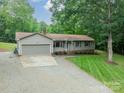 Ranch home with attached garage and driveway, surrounded by mature trees at 2109 Rock Springs Cir, Denver, NC 28037