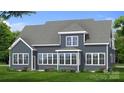 Rear exterior view with large windows and patio that provides a spacious view of the manicured lawn at 4265 Candlewood Dr, Sherrills Ford, NC 28673