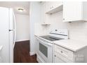 Well-lit kitchen features white cabinets, matching appliances, and dark wood-look floors at 1106 Chandler Dr, Rock Hill, SC 29732