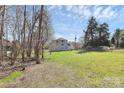 View of home from the backyard with mature trees and green space at 12300 Caldwell Rd, Charlotte, NC 28213