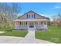 Charming single-Gathering home boasts a welcoming front porch, a well-maintained yard, and a classic gable roof design at 12300 Caldwell Rd, Charlotte, NC 28213