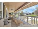 Relax on this cozy front porch complete with stylish furniture, perfect for enjoying neighborhood views at 12300 Caldwell Rd, Charlotte, NC 28213