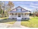 Inviting home with a classic covered porch, crisp white railings, and well-manicured front lawn at 12300 Caldwell Rd, Charlotte, NC 28213