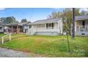 An exterior view showing the quaint home and green surroundings at 408 E Washington Ave, Bessemer City, NC 28016