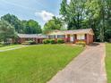 Lovely brick home featuring a manicured front lawn and a paved driveway on a sunny day at 7101 Ridgebrook Dr, Charlotte, NC 28210