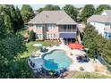 An aerial view of a backyard featuring a beautiful pool, patio furniture, and lush landscaping perfect for outdoor entertaining at 14700 Old Vermillion Dr, Huntersville, NC 28078