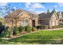 Charming brick home with well-maintained landscaping, inviting curb appeal, and a cozy, welcoming entrance at 14700 Old Vermillion Dr, Huntersville, NC 28078