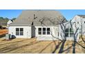 Back of house with small patio, freshly seeded yard, and view of neighborhood house at 1065 Kinship Dr # 080, Lancaster, SC 29720