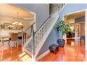 Open staircase with hardwood floors and white railings leads to the upper level at 3848 Burnage Hall Rd, Harrisburg, NC 28075