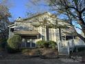 Two-story home with gray siding, multiple windows, a covered entry, and stone steps leading to each unit at 6017 Treetop Ct, Charlotte, NC 28212