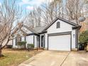 View of the home's exterior, highlighting the garage, manicured landscaping, and inviting curb appeal at 10519 Brawley Ln, Charlotte, NC 28215