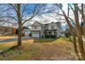 Landscaped two-story house with stone accents and a two-car garage at 1124 Woodwinds Dr, Waxhaw, NC 28173