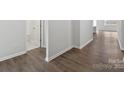 Interior shot of a hallway with wood flooring, neutral paint, and doors leading to various rooms at 1133 Hallman Branch Ln, Lincolnton, NC 28092