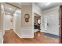 Inviting foyer with hardwood floors, white trim, front door, and wall decor adds charm to this home at 1035 Crescent Moon Dr, Fort Mill, SC 29715