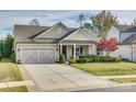 Charming one-story home with a two-car garage, manicured lawn, and covered front porch at 1035 Crescent Moon Dr, Fort Mill, SC 29715