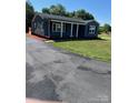 Single-story house with a covered porch, a long driveway, a green lawn, and fresh landscaping at 3596 Bethany Church Rd, Claremont, NC 28610