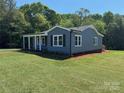 Well-maintained home boasts new siding, classic windows, a covered porch, and green lawn at 3596 Bethany Church Rd, Claremont, NC 28610