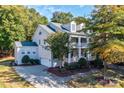 Charming two-story home featuring a manicured lawn, mature trees, and a welcoming front porch at 14027 Grand Traverse Dr, Charlotte, NC 28278