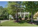 Charming two-story house with a well-manicured lawn, a two-story porch, and lush landscaping at 14027 Grand Traverse Dr, Charlotte, NC 28278