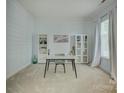 Bright office space with neutral walls, carpet, and built-in shelving next to a window and white curtains at 14027 Grand Traverse Dr, Charlotte, NC 28278