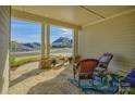 Covered porch with stone patio, wicker chairs, and a view of the street at 14535 Crosswater Ln, Charlotte, NC 28278