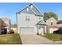 Two-story house with gray and white siding, a two-car garage, and a landscaped yard at 5723 Wallace Cabin Dr, Charlotte, NC 28212