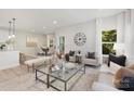 Open living space with light neutral colors, a large glass coffee table, and comfortable seating at 5723 Wallace Cabin Dr, Charlotte, NC 28212