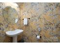 Stylish powder room with a pedestal sink and floral wallpaper at 5580 Berry Ridge Dr, Harrisburg, NC 28075