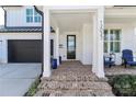 Welcoming front porch with brick steps, blue seating, and a black front door at 12023 Huntson Reserve Rd, Huntersville, NC 28078