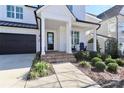 Inviting front porch with brick steps, a small seating area, and manicured landscaping at 12023 Huntson Reserve Rd, Huntersville, NC 28078