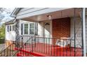 Front porch with red floor, white swing, and black railing at 1235 10Th Ne St, Hickory, NC 28601