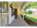 Covered porch view featuring brick accents, decorative lights, and a glimpse of the expansive front yard at 2005 Robyn Ave, Shelby, NC 28152