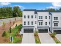 New construction exterior showcasing three-story townhomes with black accents and manicured landscaping at 2146 Barrowcliffe Nw Dr, Concord, NC 28027