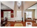 Two-story foyer with hardwood floors, chandelier, and access to dining area at 7943 Oratorio Pl, Charlotte, NC 28270