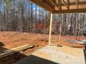 Under-construction home with a wooded backyard and patio at 9130 Dulwich Dr # Ken0079, Charlotte, NC 28215