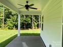 An inviting outdoor patio with a ceiling fan overlooks a lush, green backyard, perfect for relaxing at 9130 Dulwich Dr # Ken0079, Charlotte, NC 28215