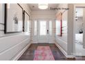 Light-filled entryway with a white door, hardwood floor, and elegant wall decor at 9130 Dulwich Dr # Ken0079, Charlotte, NC 28215