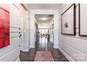 Elegant hallway featuring wainscoting, hardwood floors, and decorative artwork at 9130 Dulwich Dr # Ken0079, Charlotte, NC 28215
