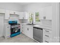 Modern kitchen featuring white cabinetry, sleek appliances, and ample countertop space at 612 E E St, Newton, NC 28658