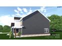 A side view shows the dark siding and a covered porch of the two-story home surrounded by green landscaping at 4615 Yellow Poplar Ln, Concord, NC 28025