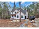 Side view of a new home featuring brick foundation and a protective wrap, complemented by wooded surroundings at 4641 Yellow Poplar Ln, Concord, NC 28025