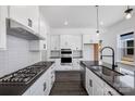 Modern kitchen with white cabinets, dark countertops, and island at 1194 Lost Cove Rd, Indian Land, SC 29707