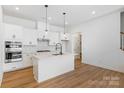 Modern kitchen island with white cabinets and quartz countertops at 1198 Lost Cove Rd, Indian Land, SC 29707